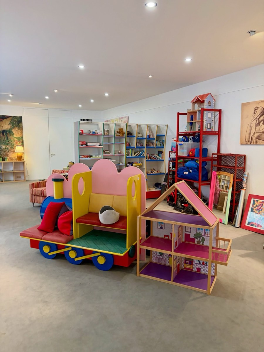 Eine Spielzeugeisenbahn aus Holz und ein Puppenhaus in der Kinderecke