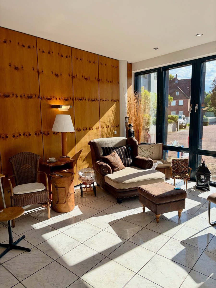 Ledersessel mit Hocker vor einer Holzwand