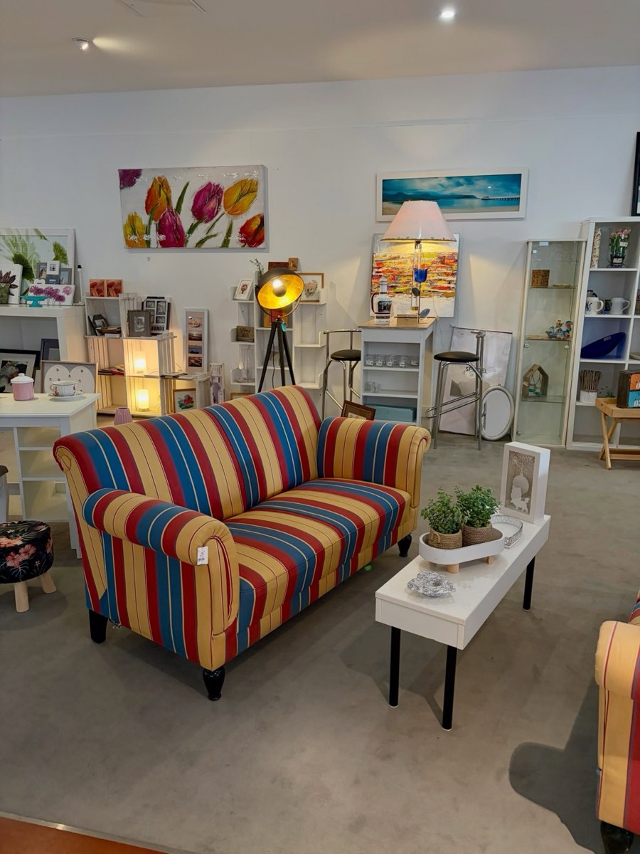 Ein gestreiftes Sofa mit Couchtisch, Lampen und Bildern an der Wand